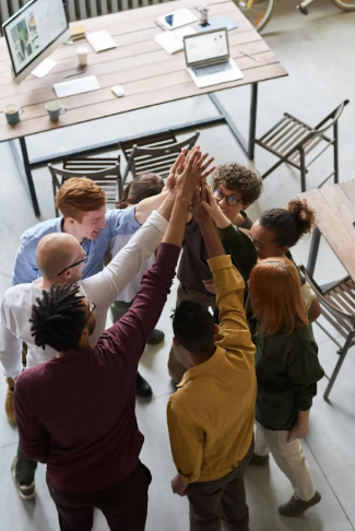 a group of people standing around each other with their hands in the air