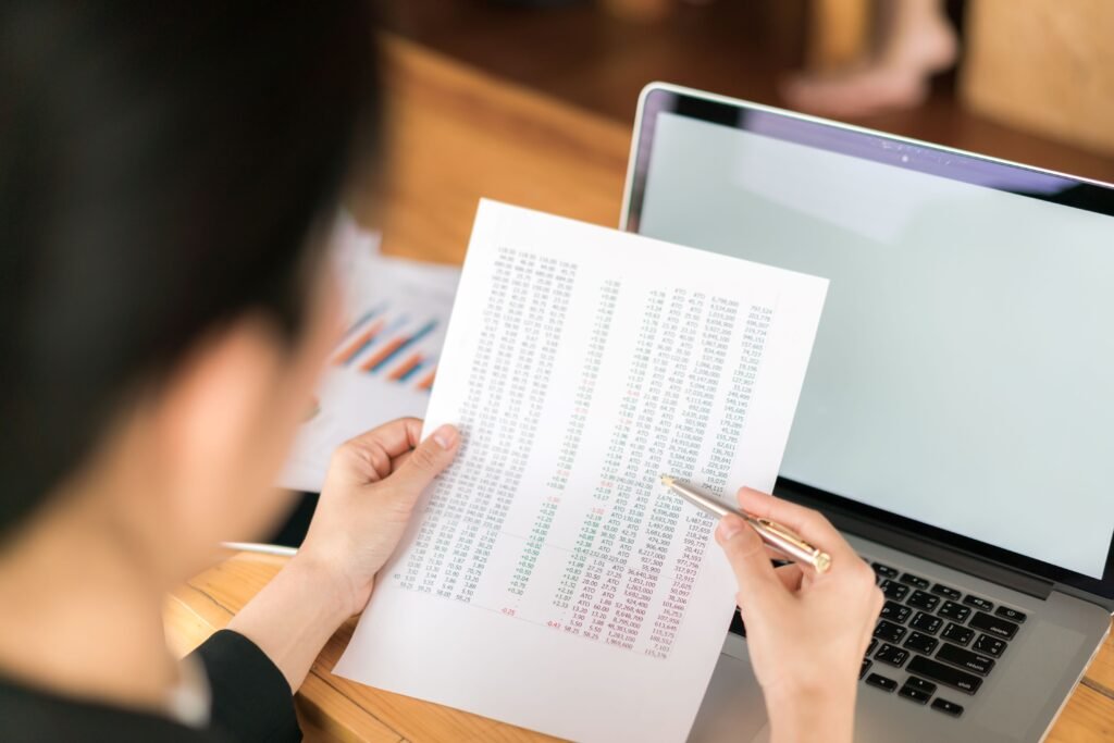 business-woman-hand-with-financial-charts-laptop-table